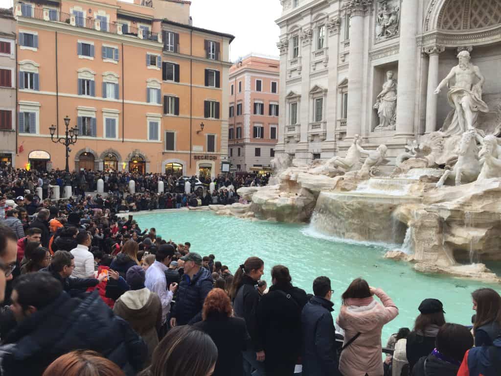 Trevi fountain during the day with a huge crowd around it