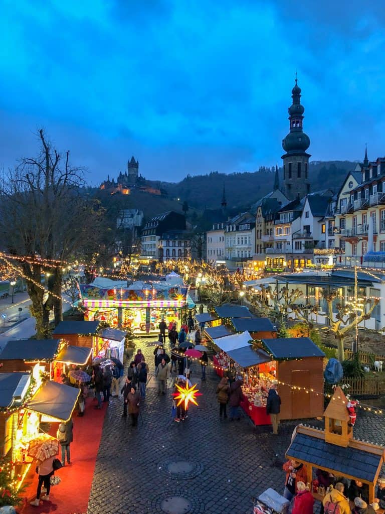 Christmas market with lights and little stalls and a grey blue sky