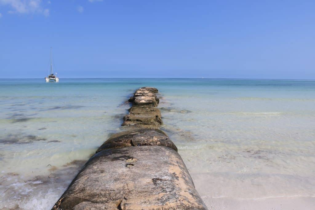 Stones in the ocean and a little white boat