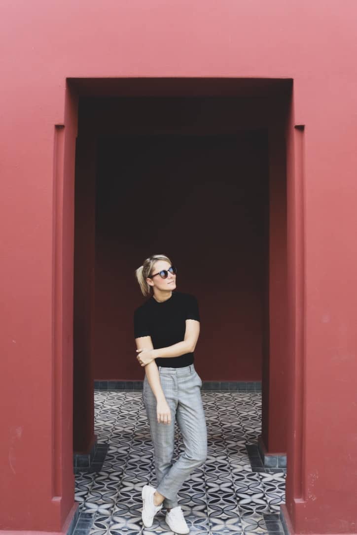 Girl next to brown walls in le jardin secret marrakech