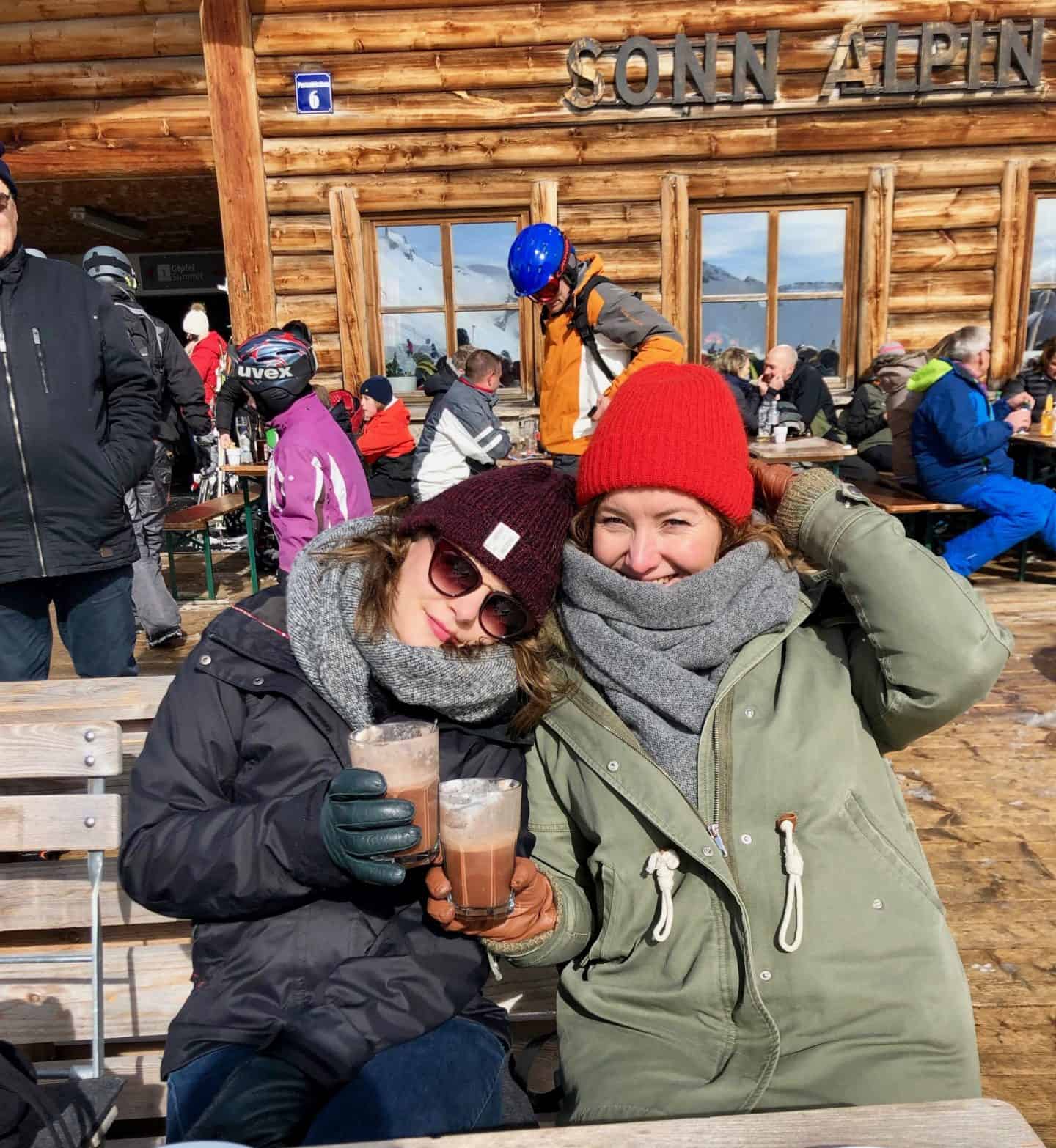 two girls with jackets on and hot chocolates