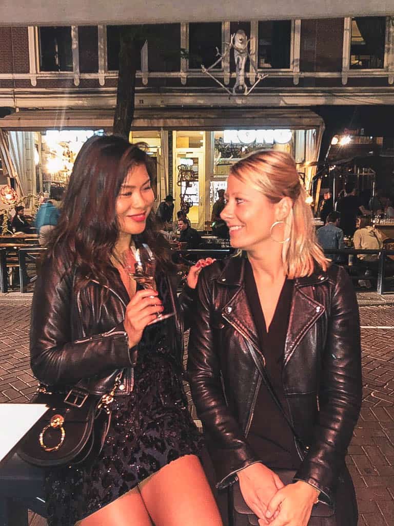 Two girls with leather jackets sitting in de witte de withstraat in Rotterdam