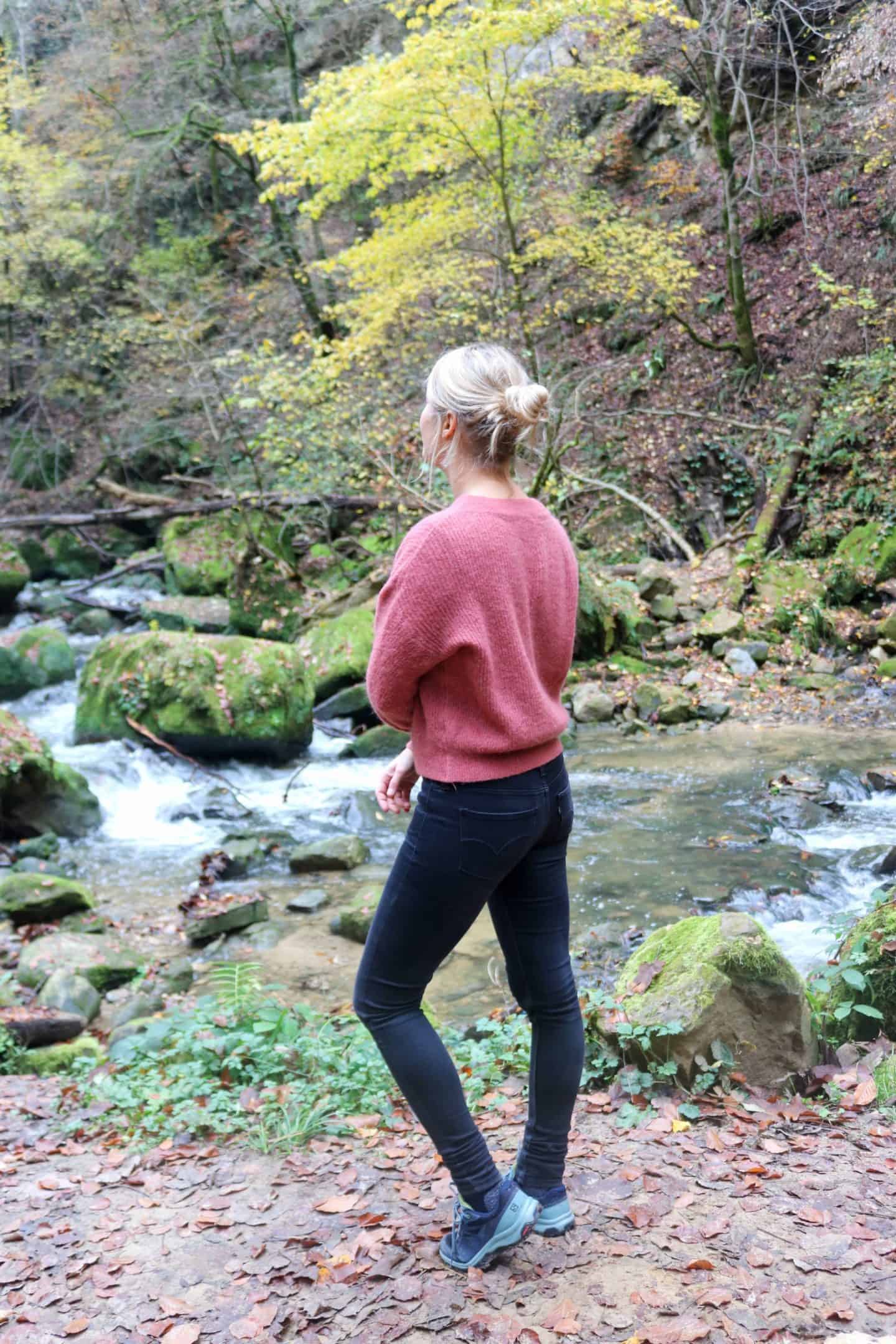 Girl in front of a river hiking müllerthal trail